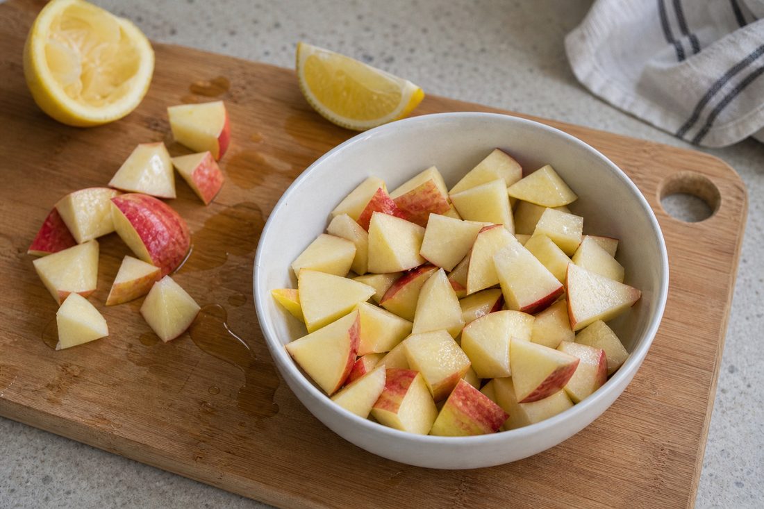 Apple chunks tossed with lemon juice before packing an apple cheddar chicken salad.