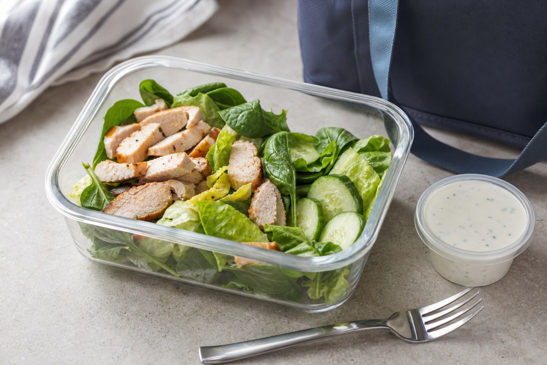 A romaine chicken salad box with a separate sealed creamy herb dressing cup.