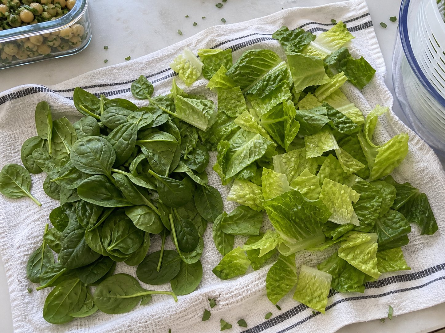 Spinach and romaine drying on a towel before packing egg and chickpea protein salad.