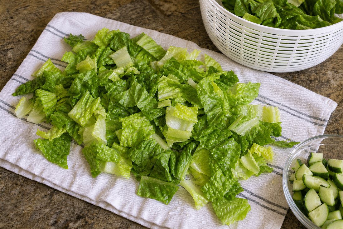 Chopped romaine drying for lemon pepper chicken cucumber salad.