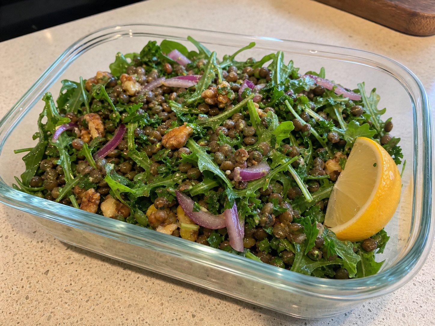 Finished lentil lemon Dijon salad lightly tossed with arugula, parsley, red onion, walnuts, and lemon Dijon dressing.