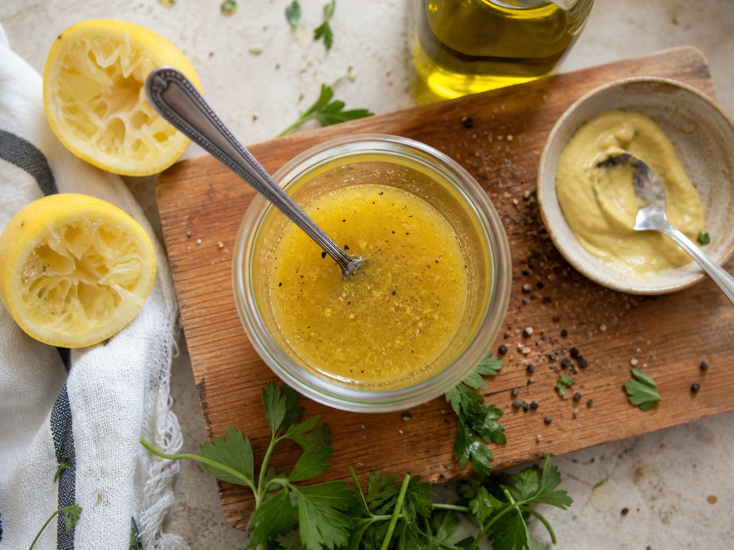 Lemon Dijon dressing in a small jar with lemon, mustard, olive oil, parsley, and pepper for lentil salad.