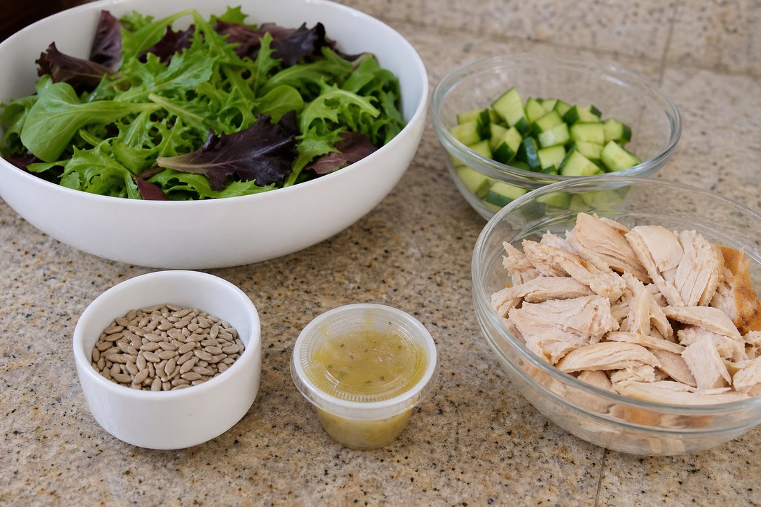 Sunflower seeds kept separate beside rotisserie chicken salad components.