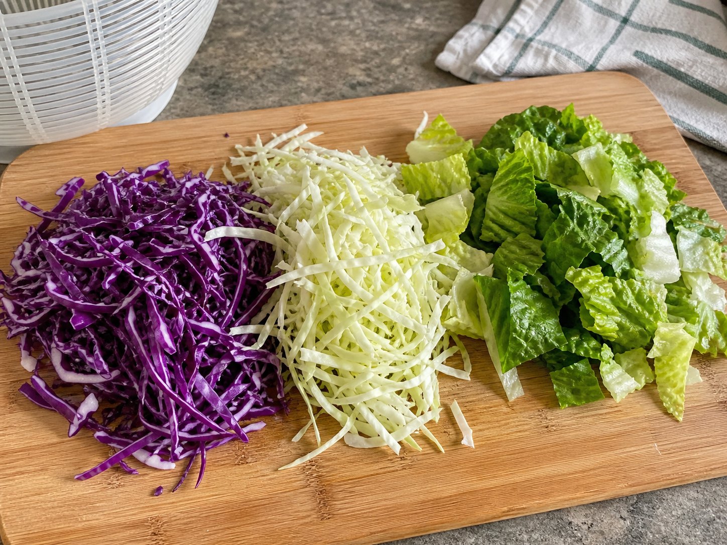 Shredded purple cabbage, pale cabbage, and chopped romaine for sesame tofu cabbage salad.