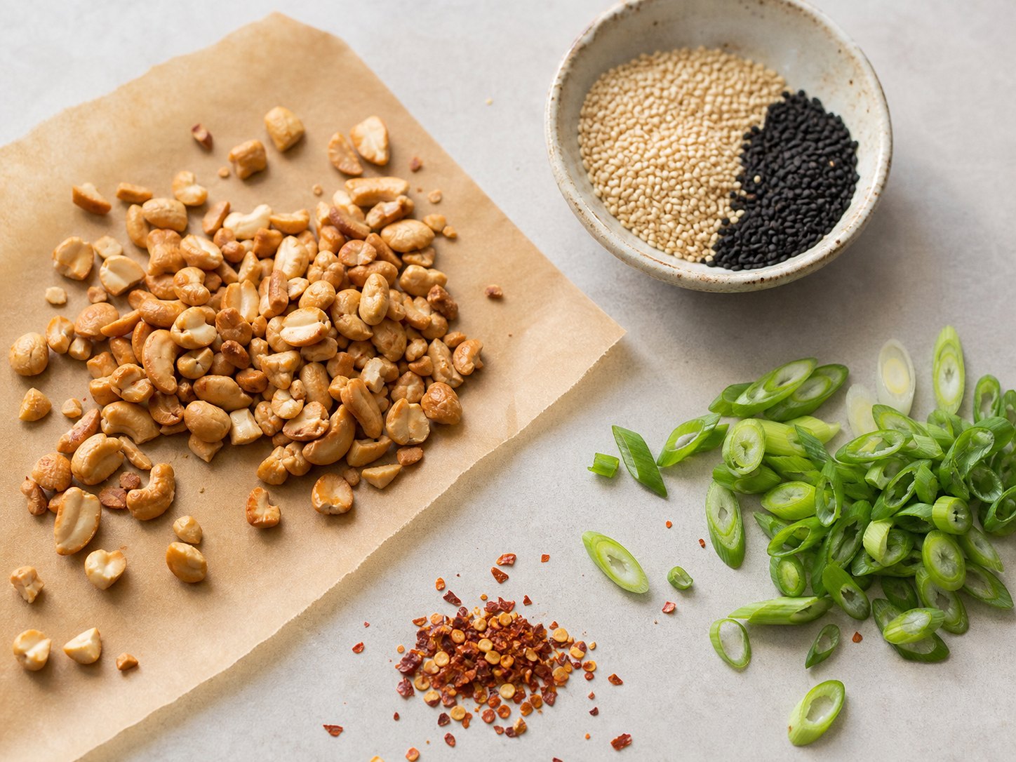 Toasted cashews, sesame seeds, scallions, and chili flakes for sesame tofu cabbage salad.