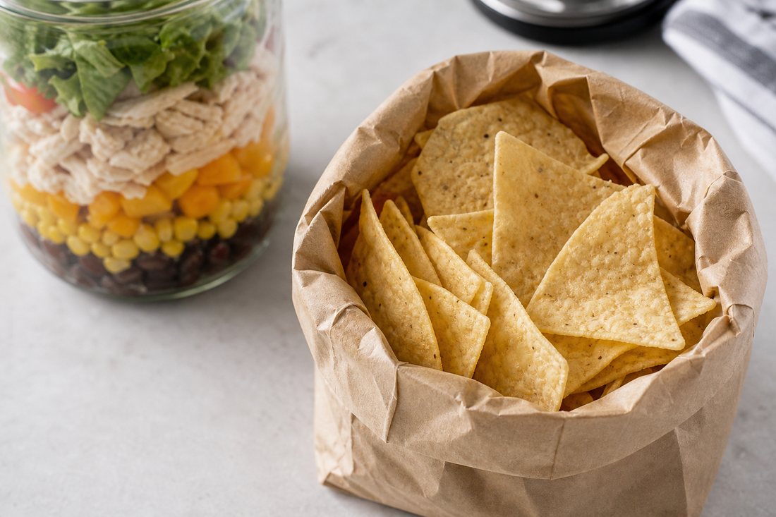 Tortilla chips packed separately from a Southwest chicken salad jar.